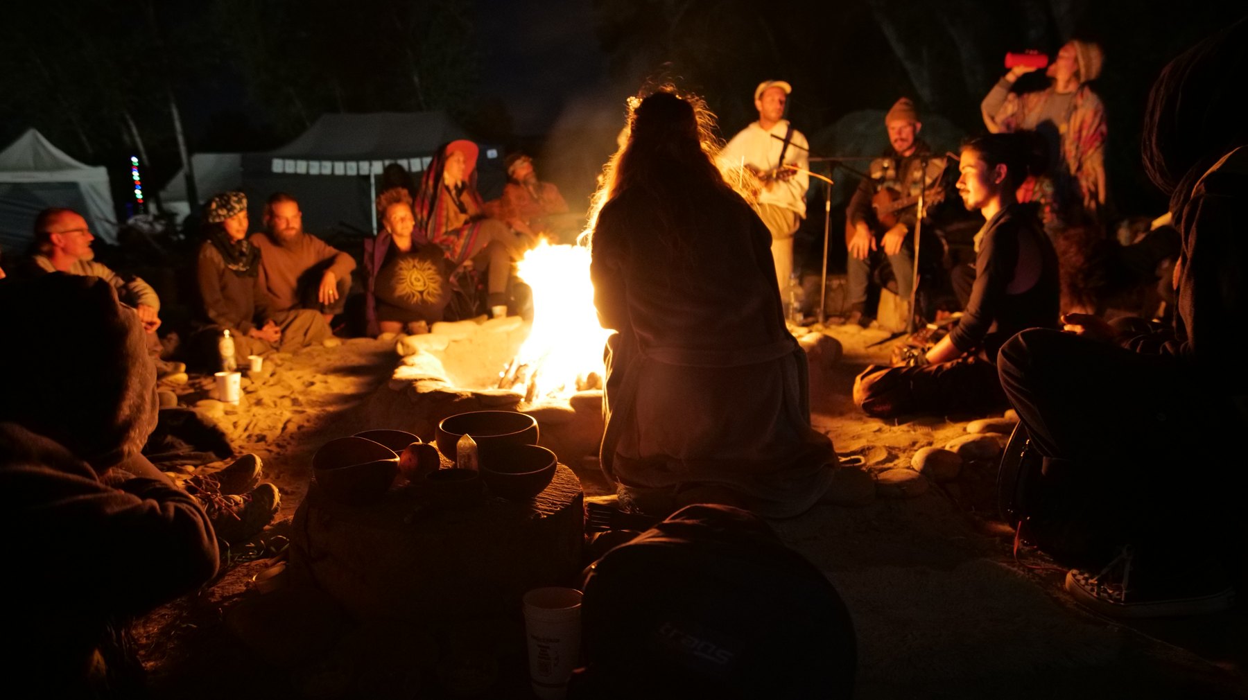 A DRMA fire circle at night — live music and community around the fire