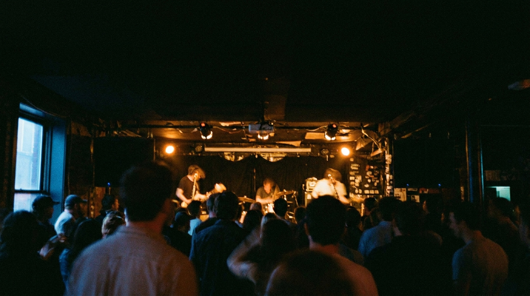 A band playing to a crowd at a small venue